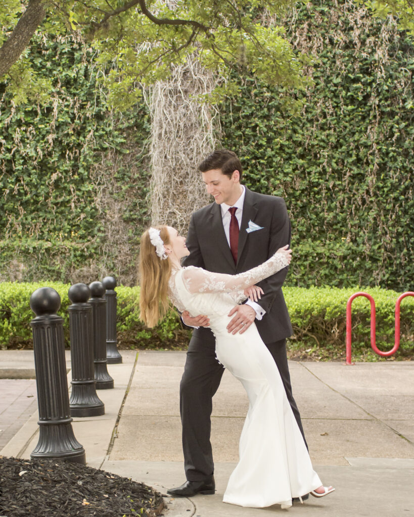 A groom dipping his bride down and gazing into her eyes during their special occasion