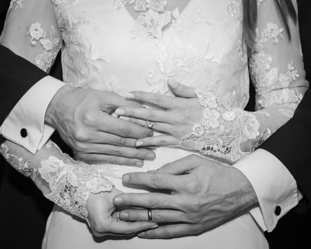 A close of shot of a bride and grooms hands, exchanging wedding rings